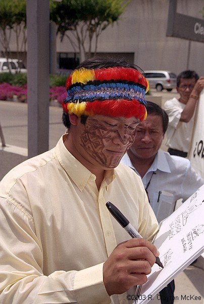 Presidents of the Amazon Federations of Ecuador and supporters held a press conference/demonstration outside the Galleria offices of Burlington Resources to reject officially any oil exploration or development activity in the Block 24 area of the Ecuadorian Amazon. Milton Callera, President of FINAE, the Achuar Federation, signs a symbolic "eviction notice" ordering Burlington to cease and desist all oil-related activities and leave indigenous lands.