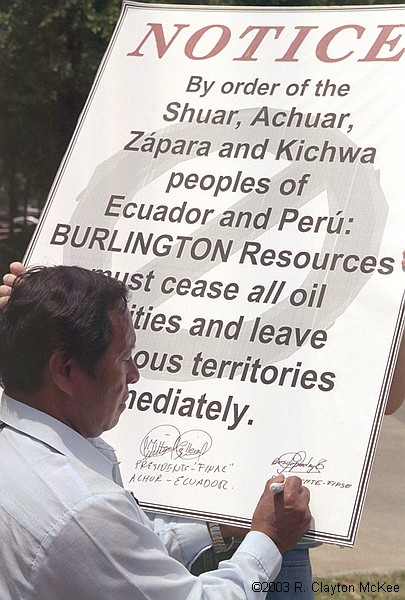 Presidents of the Amazon Federations of Ecuador and supporters held a press conference/demonstration outside the Galleria offices of Burlington Resources to reject officially any oil exploration or development activity in the Block 24 area of the Ecuadorian Amazon. Bosco Najamdey, President of FIPSE, signs a symbolic "eviction notice" ordering Burlington to cease and desist all oil-related activities and leave indigenous lands.